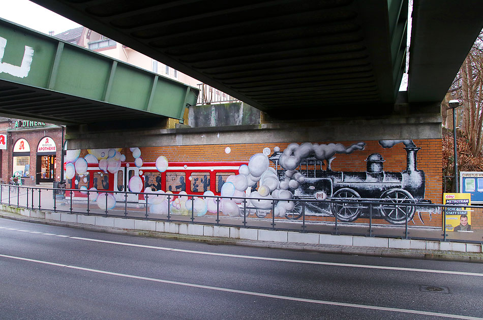 Ein Wandbild am Bahnhof Othmarschen eine Dampflok schleppt eine S-Bahn der Baureihe 474 ab