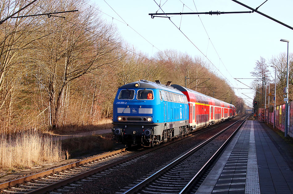 Die Press 218 055-2 vor einem RE von Hamburg-Altona nach Westerland auf Sylt im Bahnhof Prisdorf