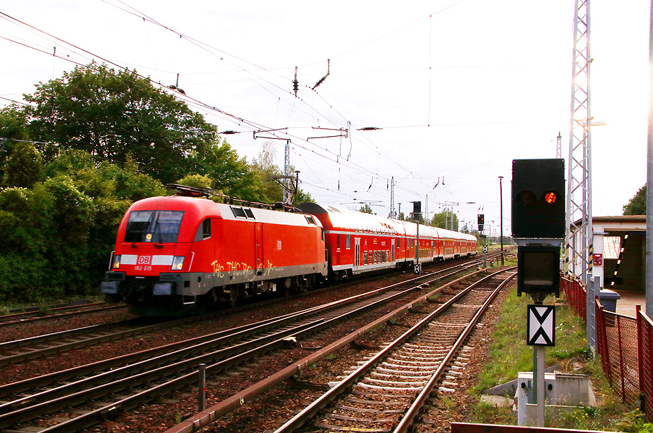 Eine Lok der Baureihe 182 fährt am Bahnhof Berlin-Wuhlheide mit einem RE vorbei