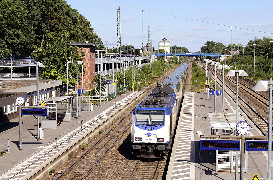 Ein Metronom Zug im Bahnhof Tostedt mit dem Parkhaus für Autos