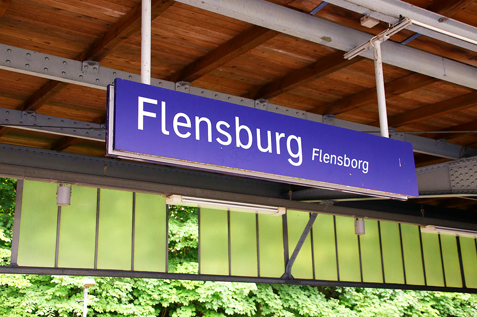 Ein Bahnhofsschild vom Bahnhof Flensburg / Flensborg